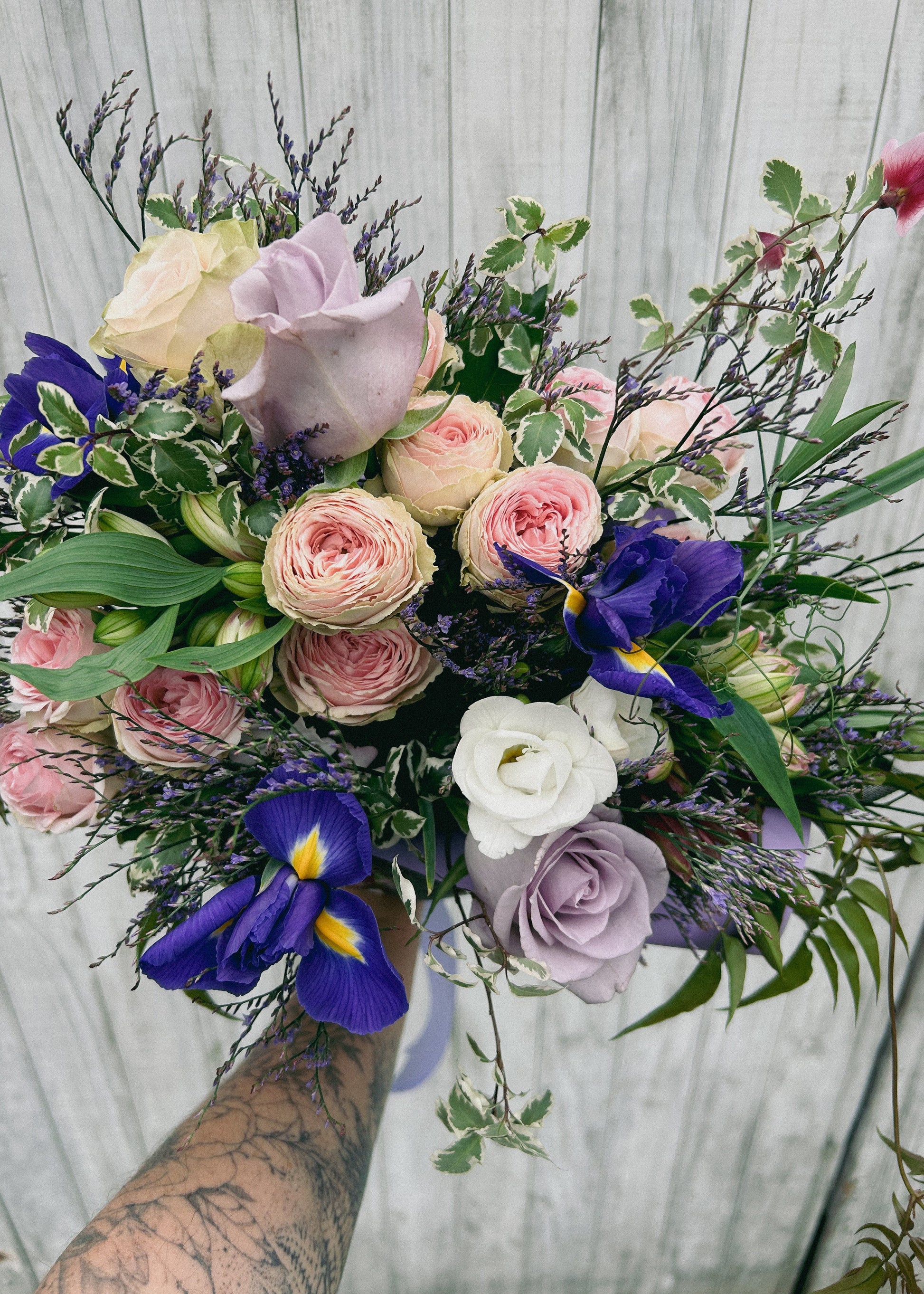 Bouquet of flowers with pink, purple, and blue colors against a neutral background
